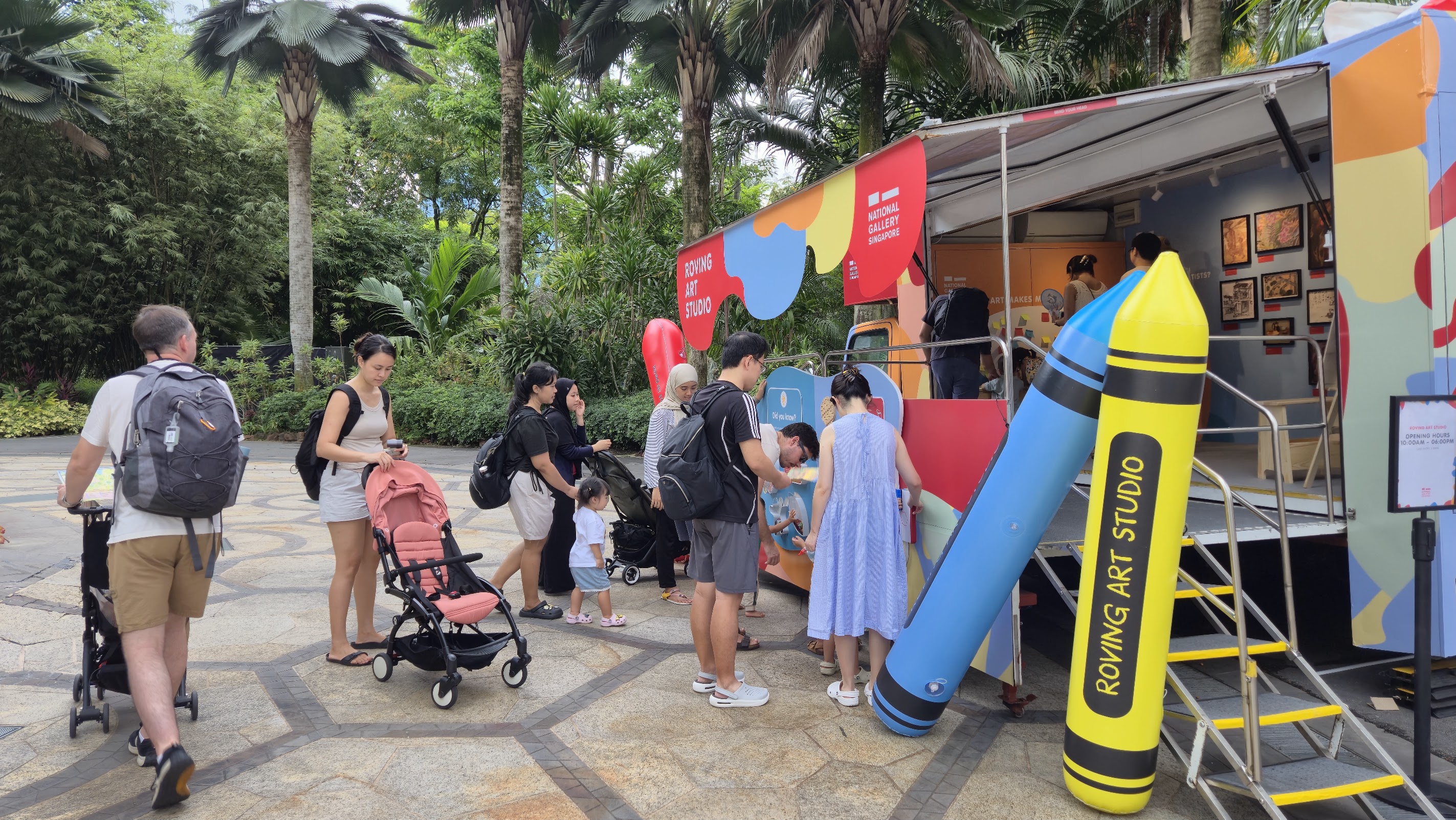 A group of people gathers around a art truck, engaging in conversation and enjoying artworks and crafts at the Walk for Our Children 2026 event.
