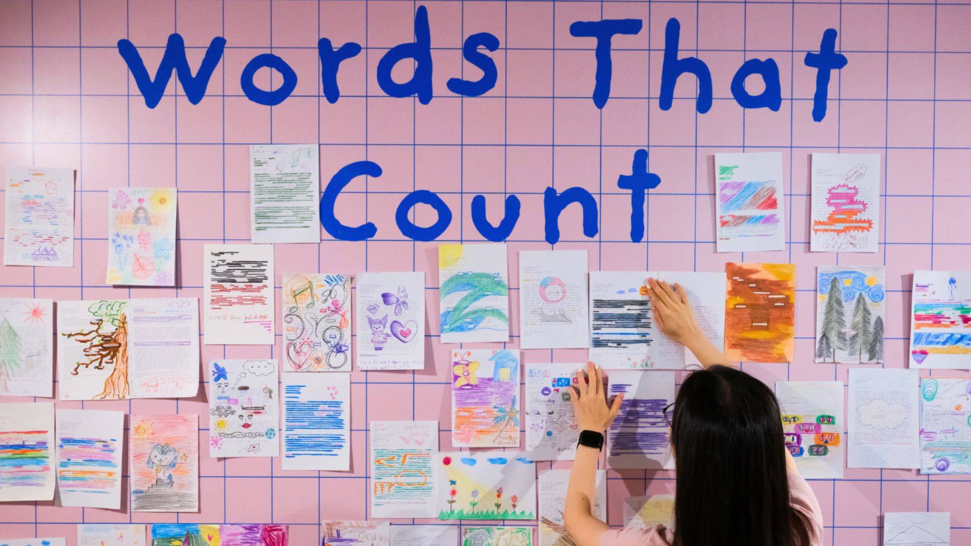 A woman writes meaningful words on a wall, inspired by Georgette Chen's vibrant artwork of old Singapore's waterfront.