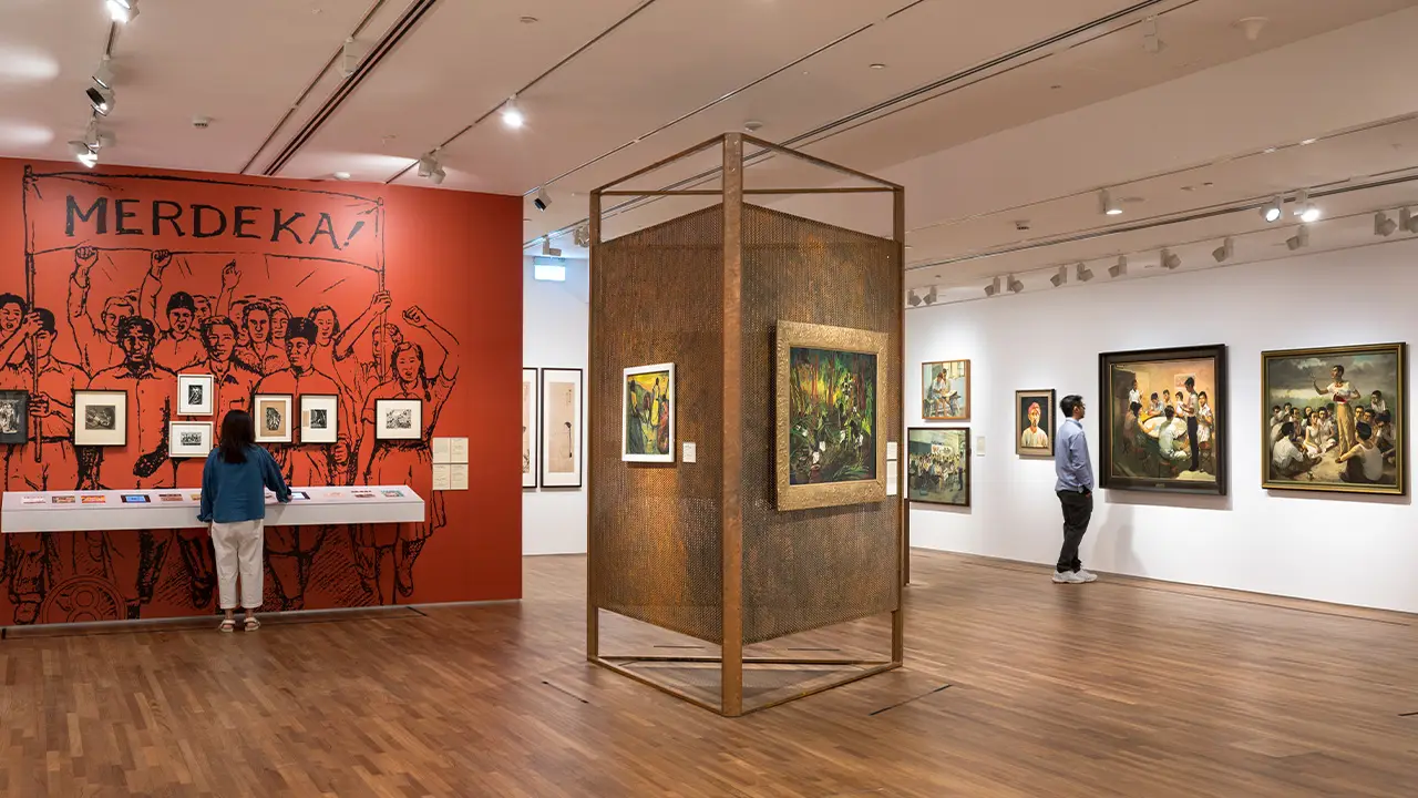 Gallery with red walls showing an assortment of portraits.
