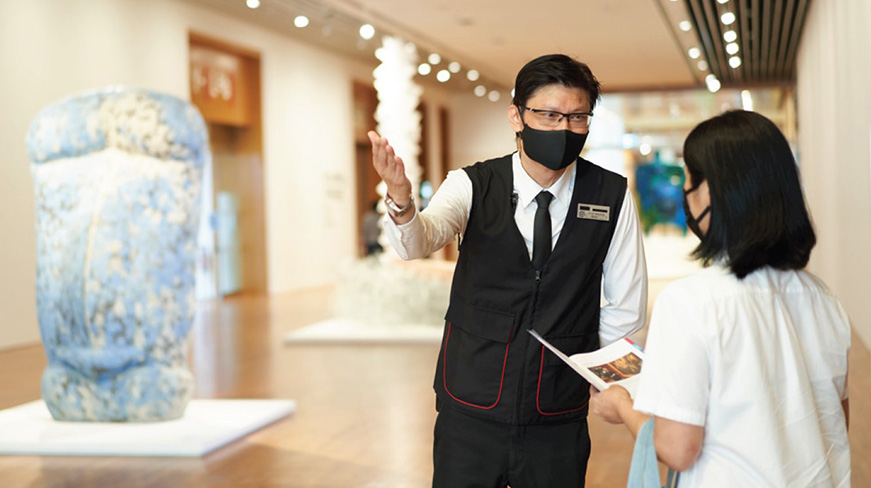 A uniformed security officer interacting with a visitor