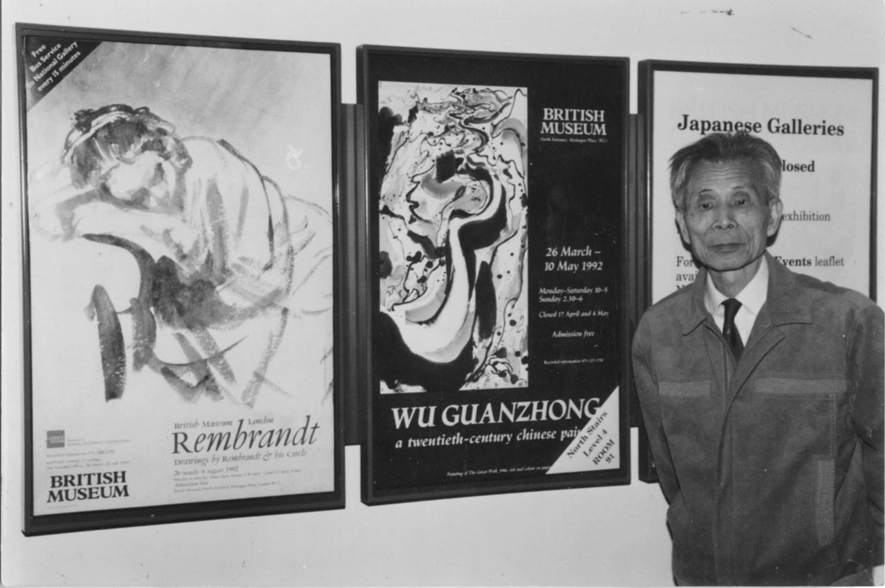 Photograph of Wu Guanzhong before the banner of his exhibition titled "Wu Guanzhong: A Twentieth-century Chinese Painter"