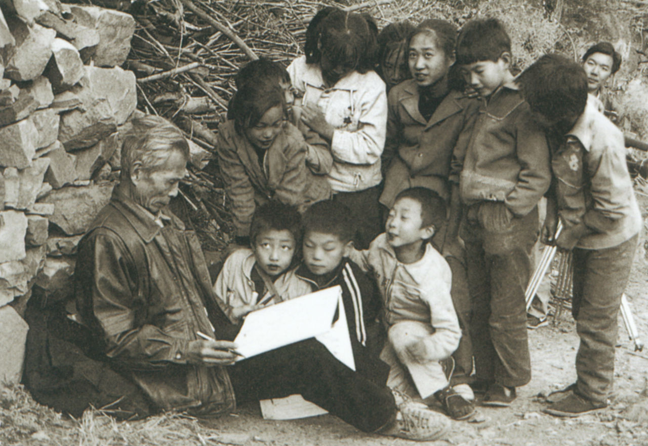 Photograph of Wu Guanzhong sketching with a group of students in a fishing village in Shandong