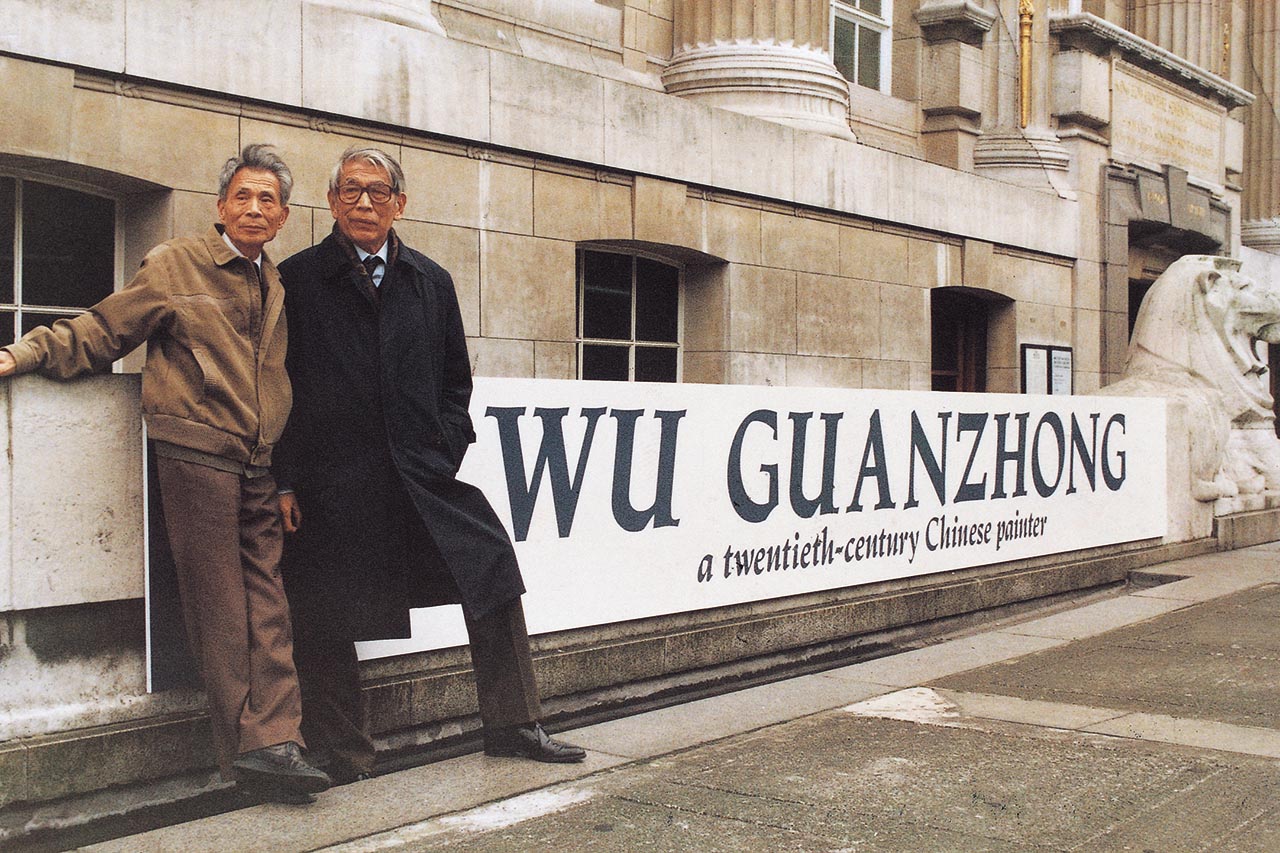 Photograph of Wu Guanzhong and Chu Teh-Chun before the banner of Wu's exhibition titled "Wu Guanzhong: a twentieth-century Chinese painter"