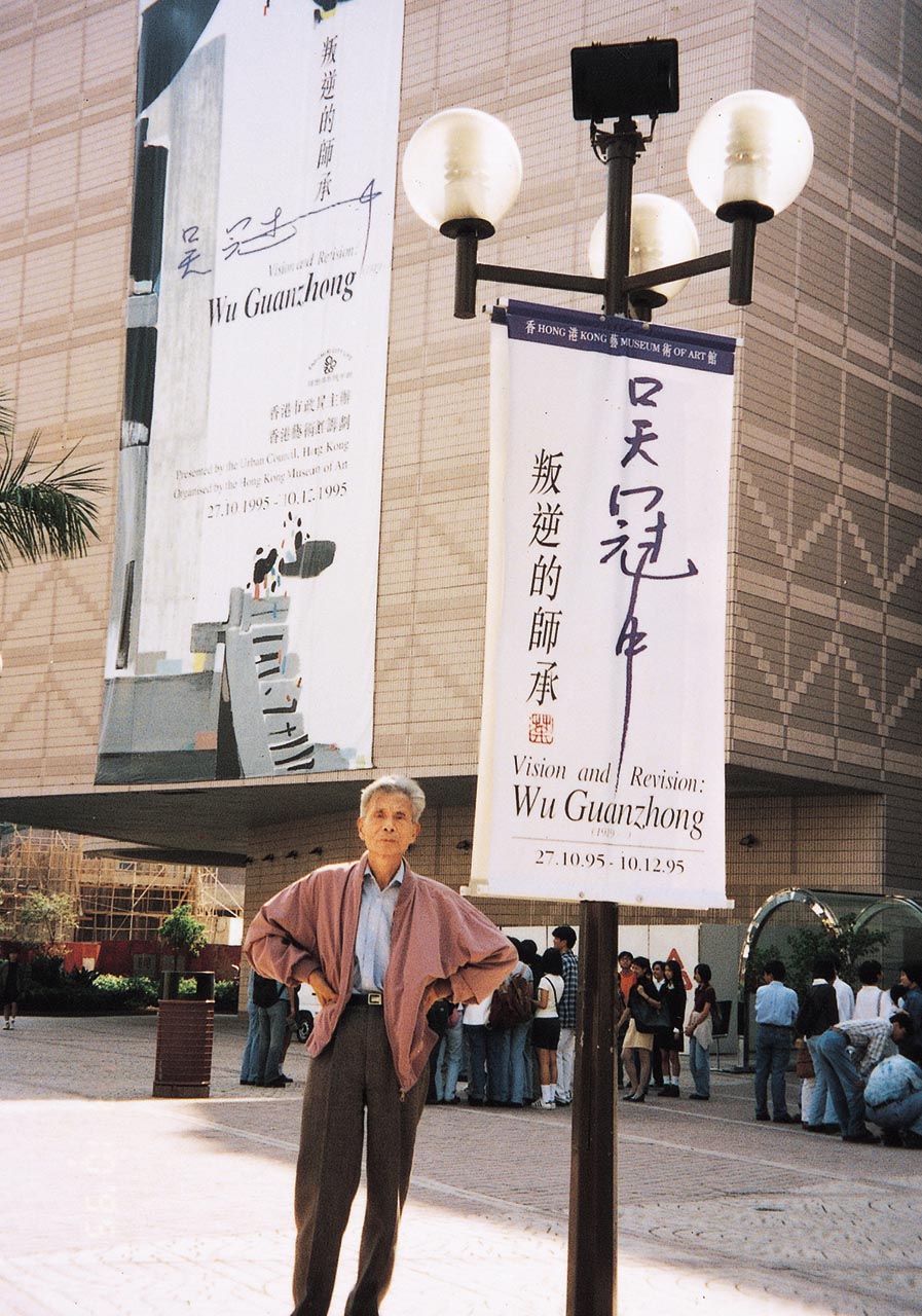 Photograph of Wu Guanzhong before the banner of his exhibition titled "Vision and Revision: Wu Guanzhong"