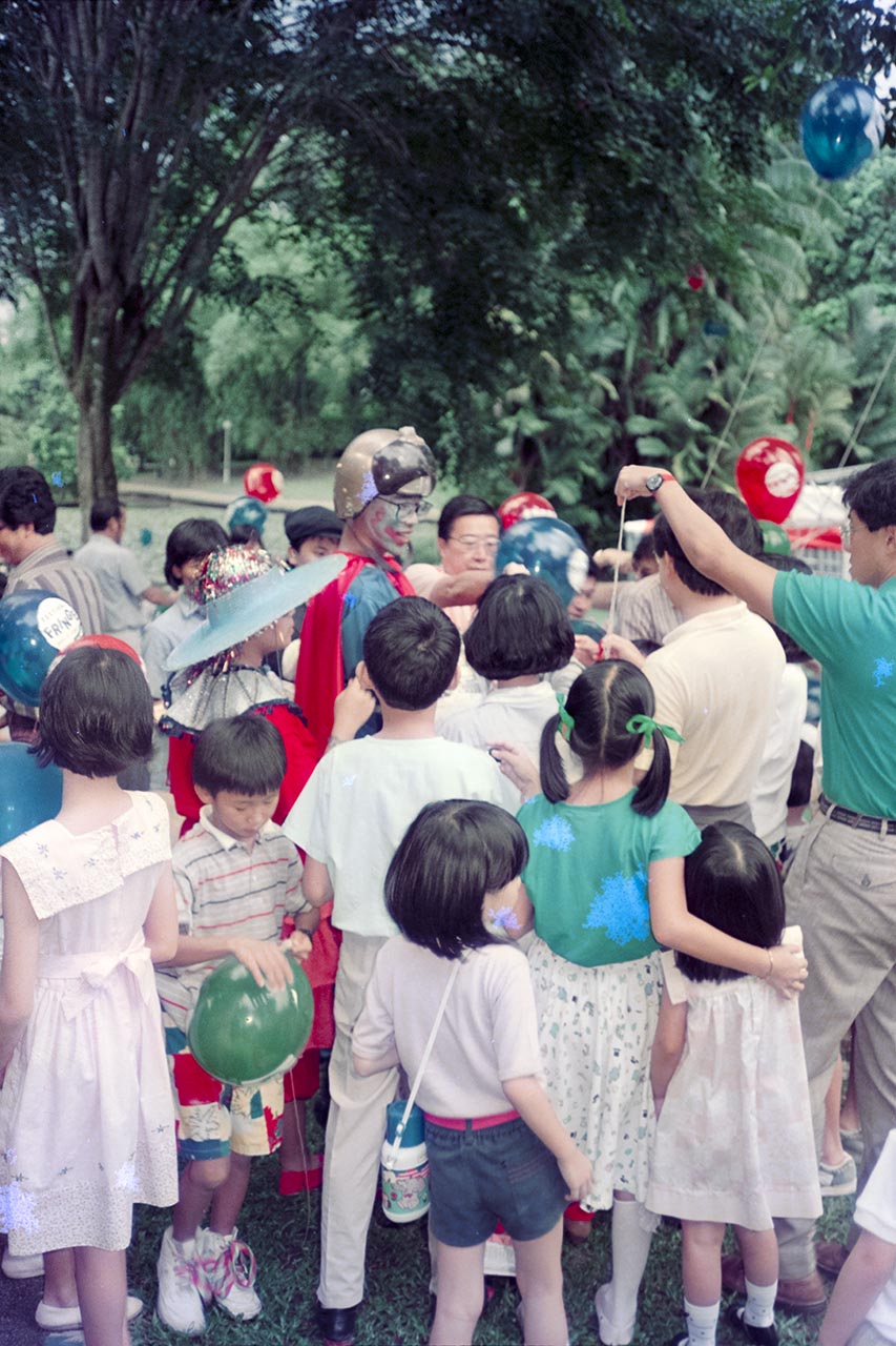 Photographic documentation of a clown distributing balloons at the Singapore Botanic Gardens