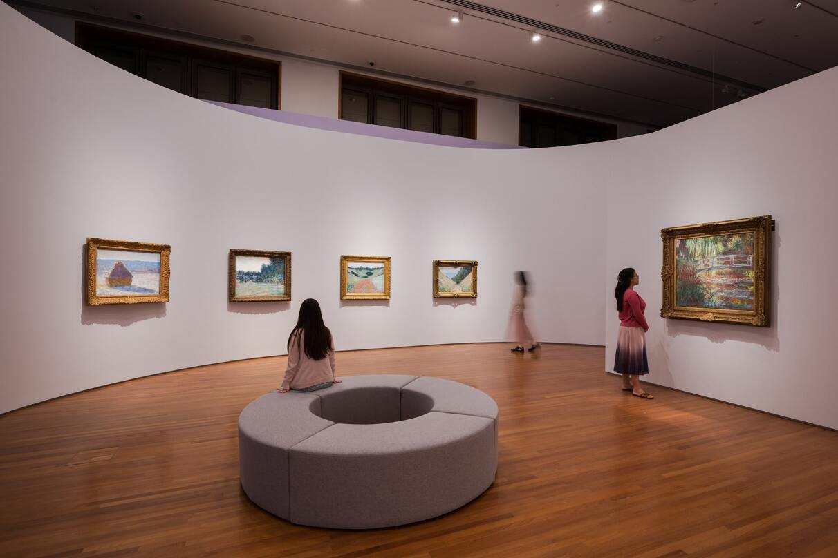 Circular white room with Monet paintings mounted on the wall