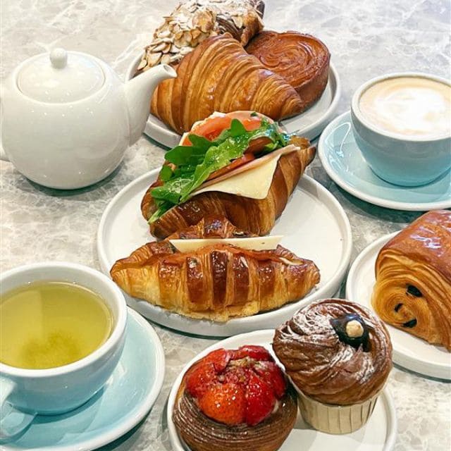 A baking sheet filled with a variety of pastries, featuring different sizes and toppings, ready for serving.