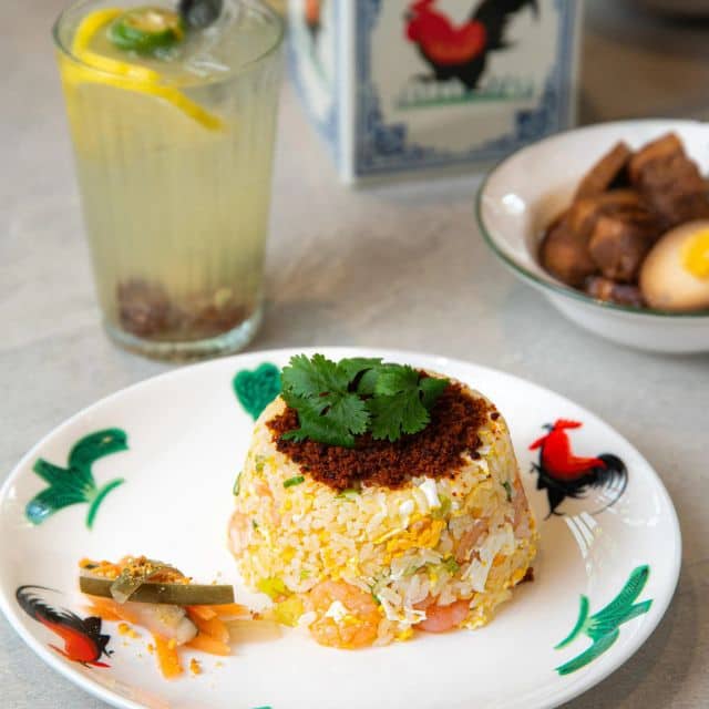 A plate of fried rice garnished with vegetables, showcasing a vibrant and flavorful dish inspired by local Singaporean cuisine.