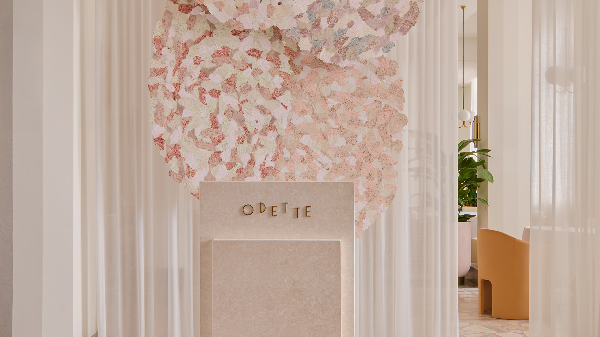 Pink hostess stand at the newly renovated Odette space, with pink petal artwork and curtains