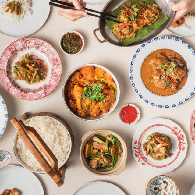 A beautifully arranged table featuring various plates of heirloom Eurasian dishes and wine, celebrating heritage.