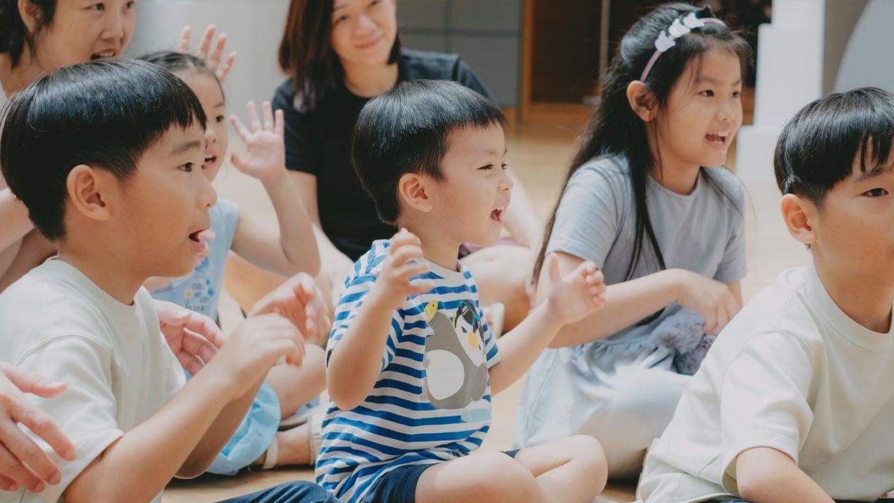 Group of children clapping and cheering during a performance