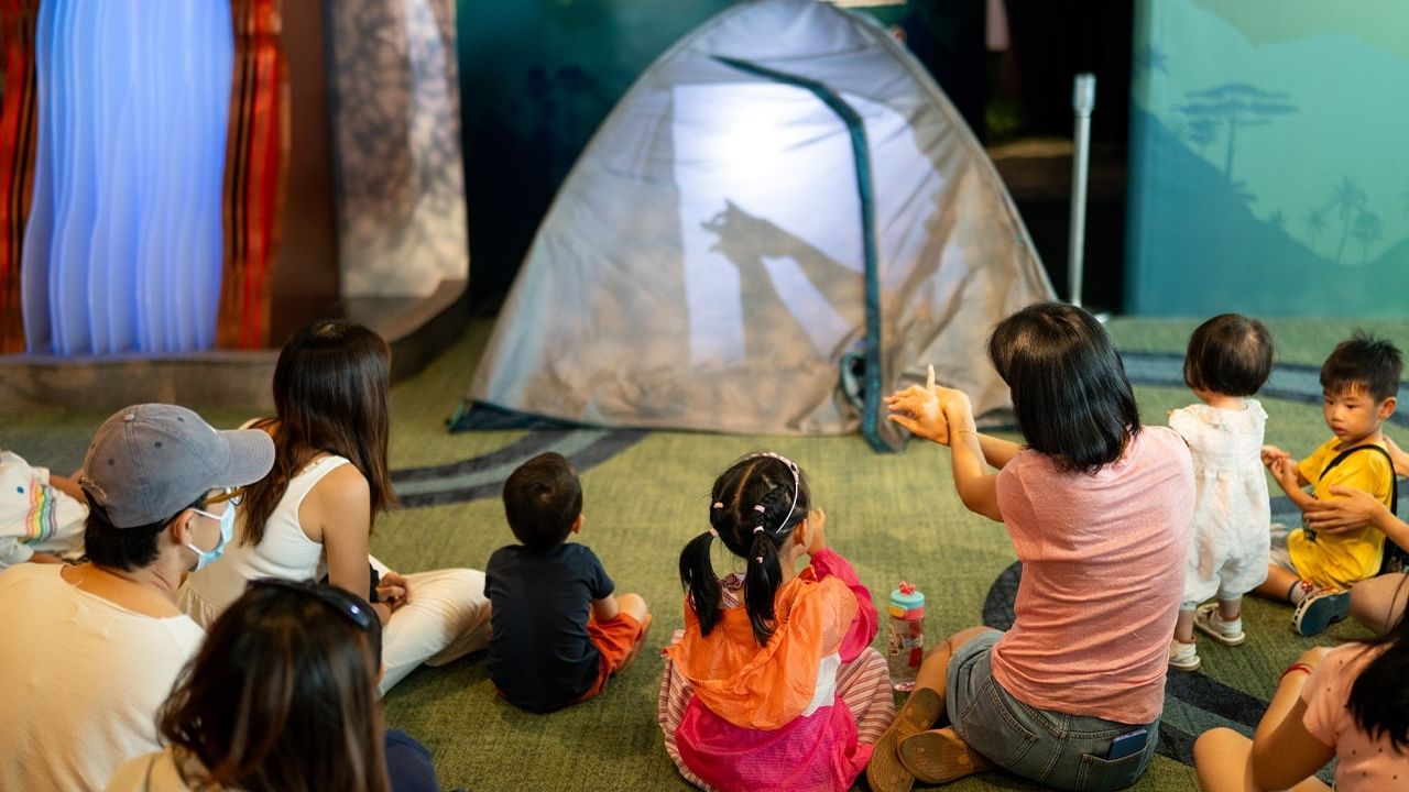 Group of children and their parents watching a shadow performance.