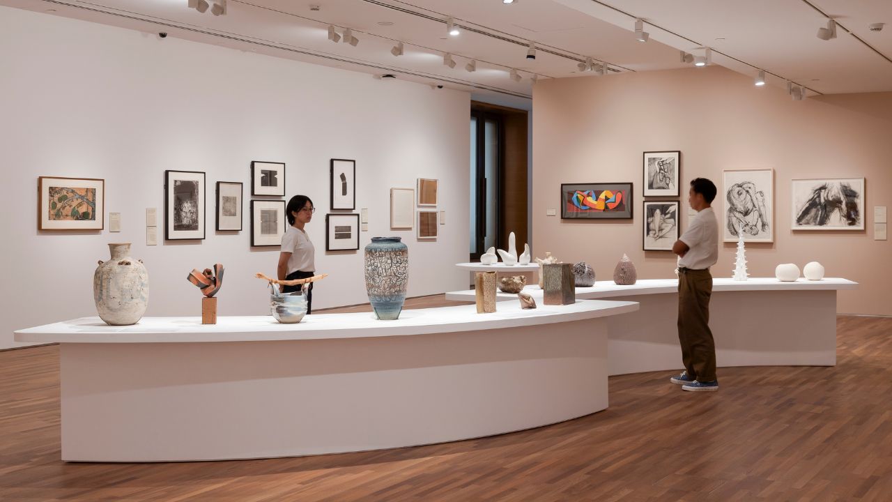 Gallery installation with white stands displaying ceramic artworks