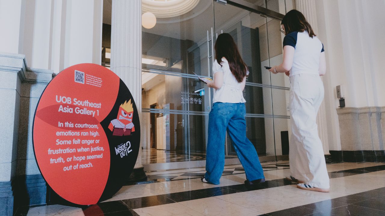 2 female visitors on a self-guided trail, featuring Disney's Inside Out 2 inspired trail markers next to the Gallery's entrance.