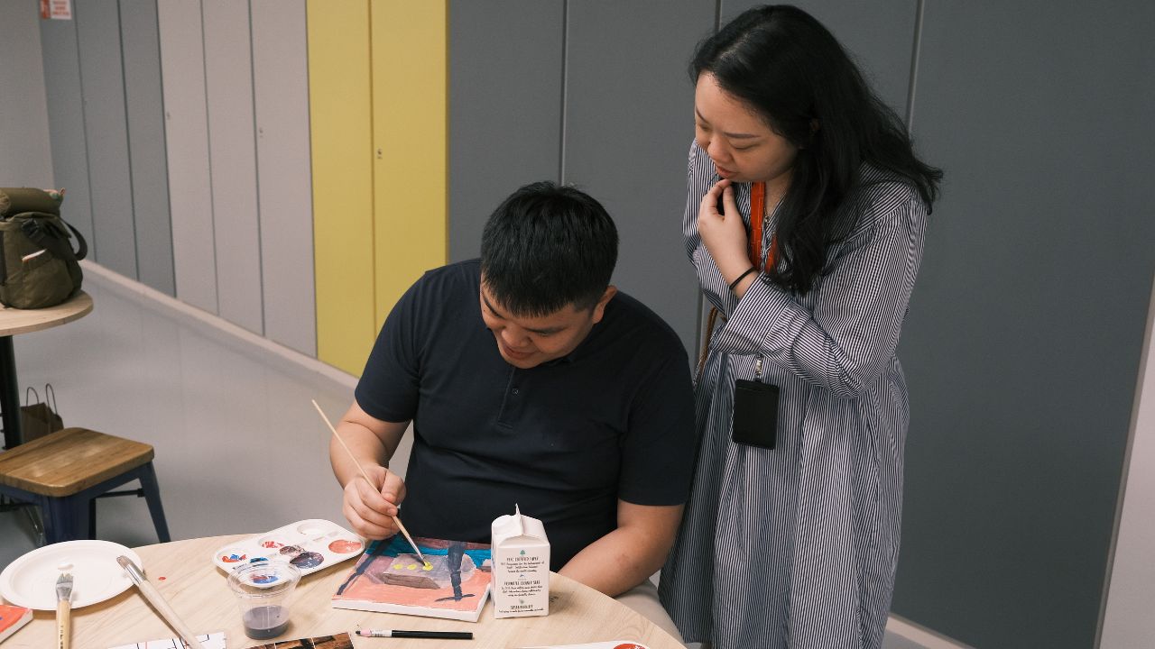 A couple engages in a craft project together, highlighting the interactive and inspiring atmosphere of the gallery's workshops.
