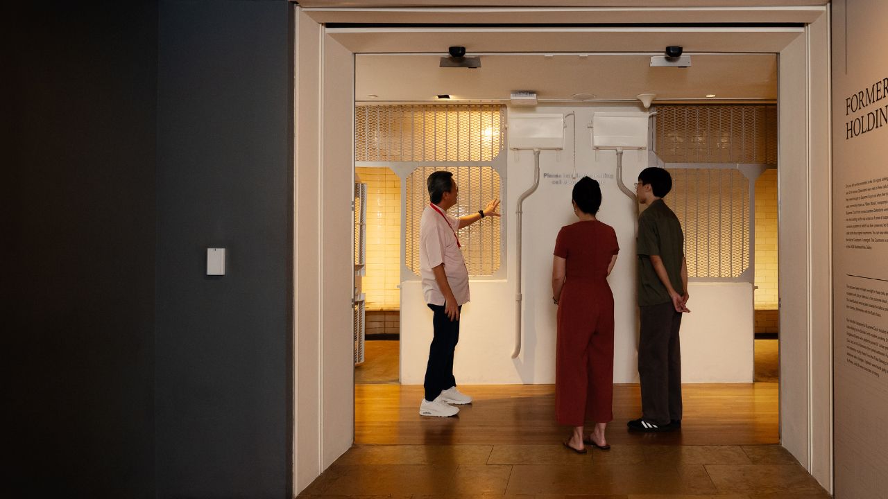 A couple on tour with a Gallery docent, who is describing historical features of the Gallery's wings.