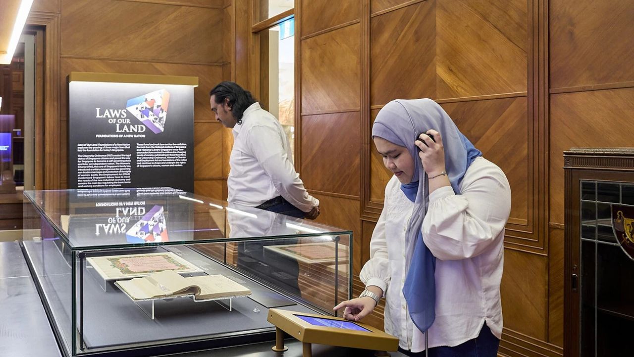 Pair of visitors listening to audio clips at the Laws of our land exhibition