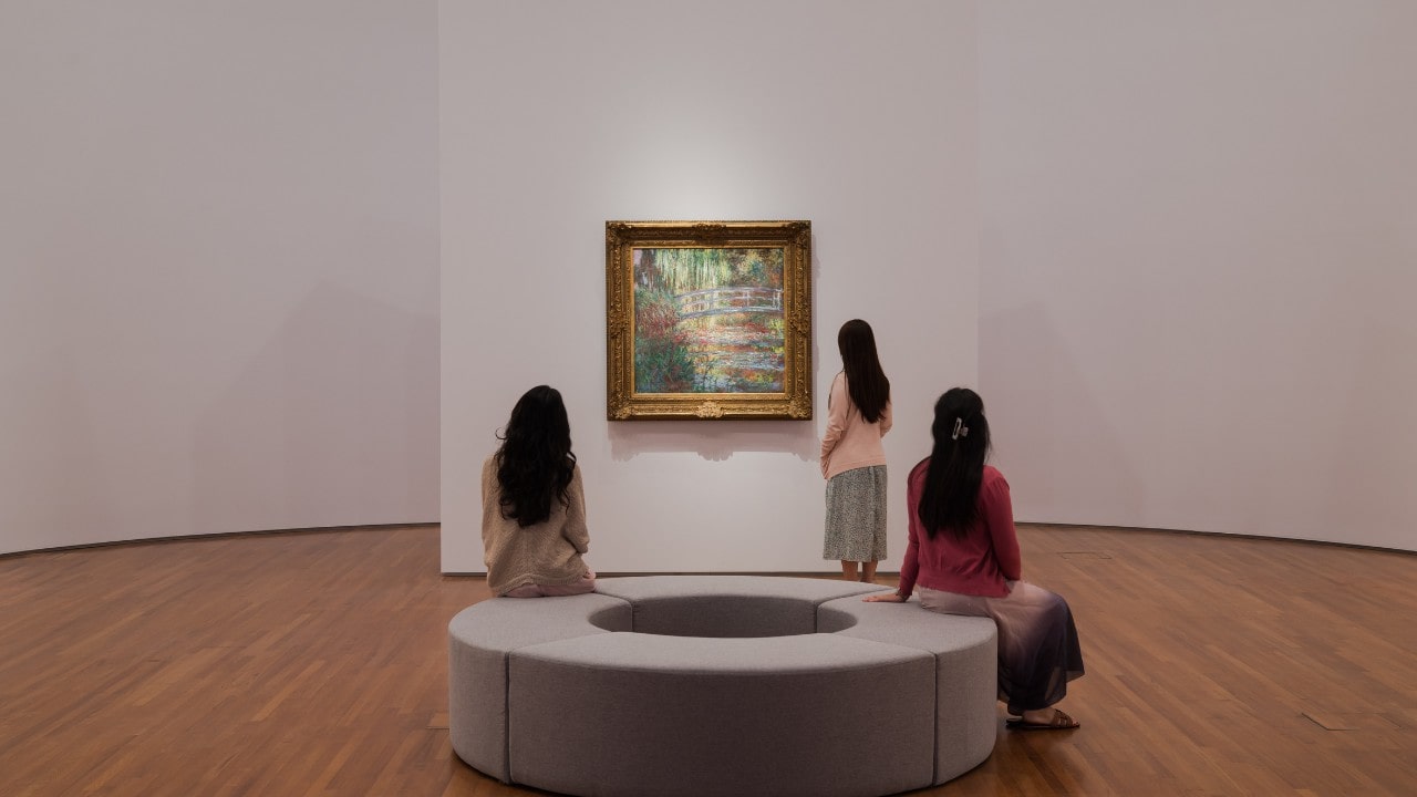 Guests seated in front of Monet painting at the Into the Modern exhibition