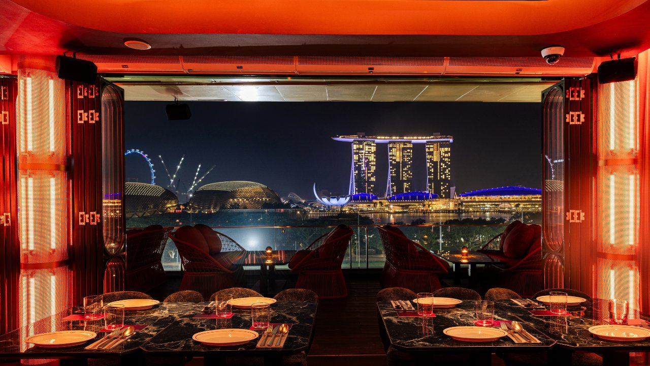 A lively entertainment space and DJ booth overlooking the Singapore skyline at Milli Sky Bar and Lounge.