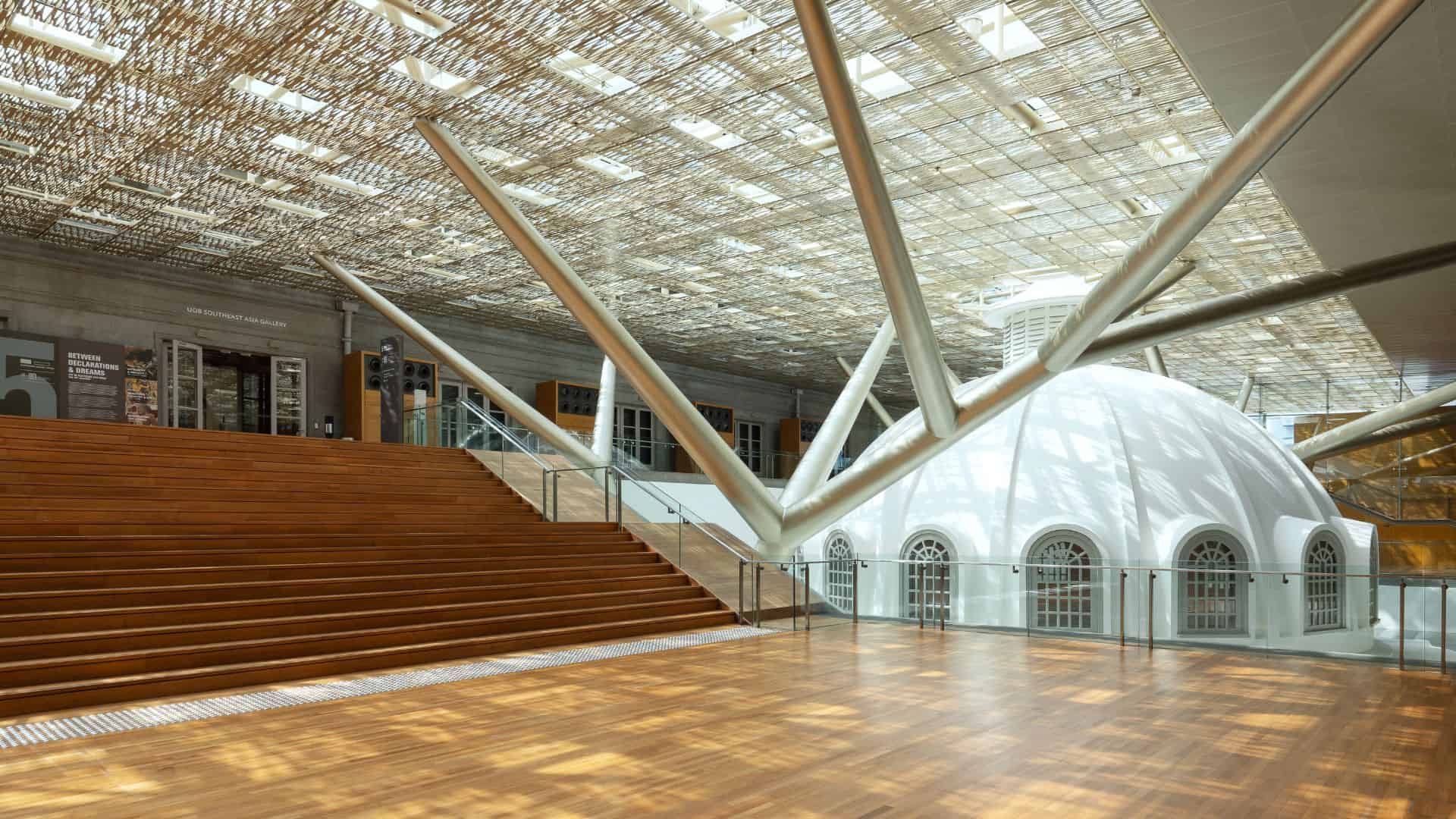 A spacious white dome interior featuring wooden floors and stairs, creating a bright and inviting atmosphere.