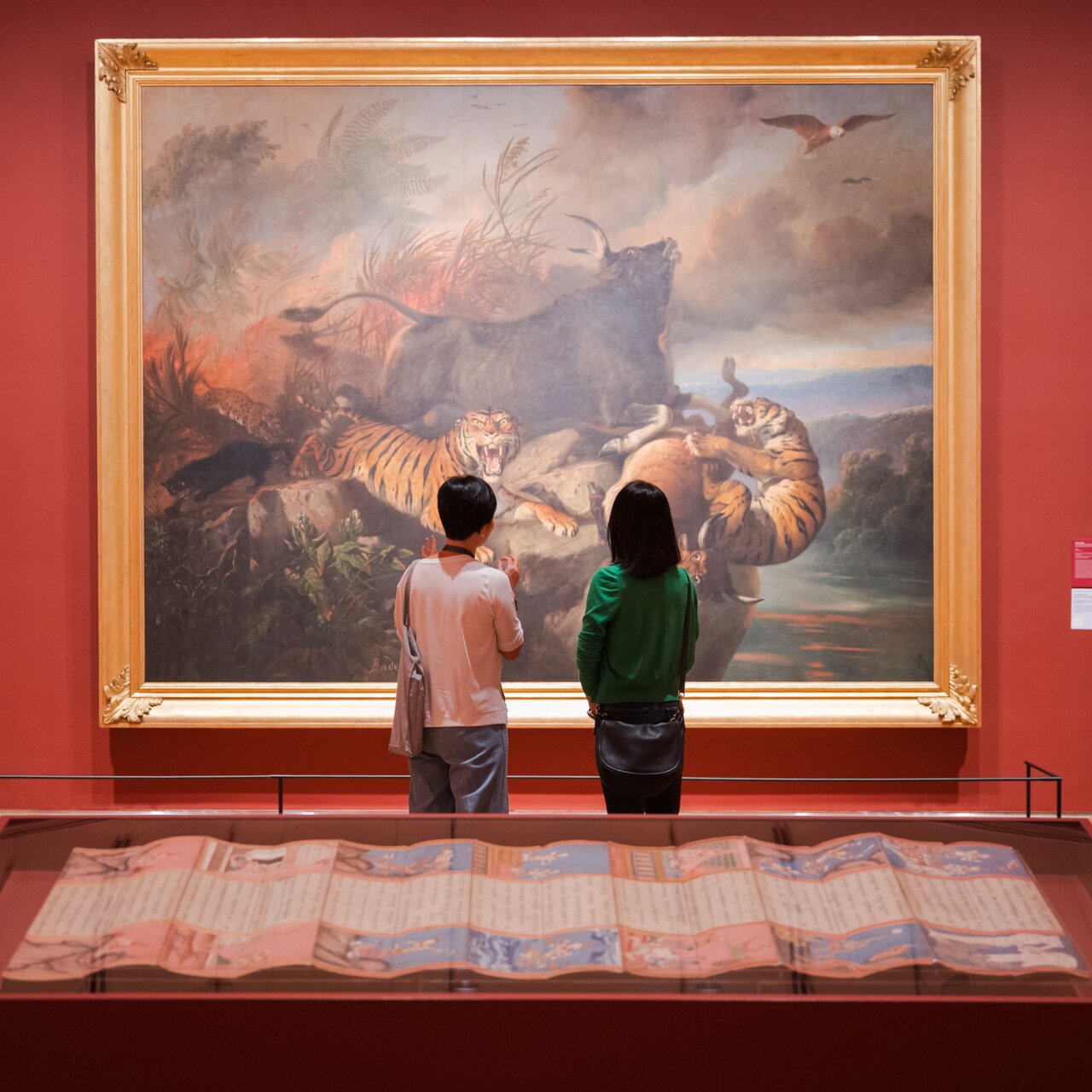 Two visitors admire a painting at the exhibition "Between Declarations and Dreams" showcasing Southeast Asian art history. 