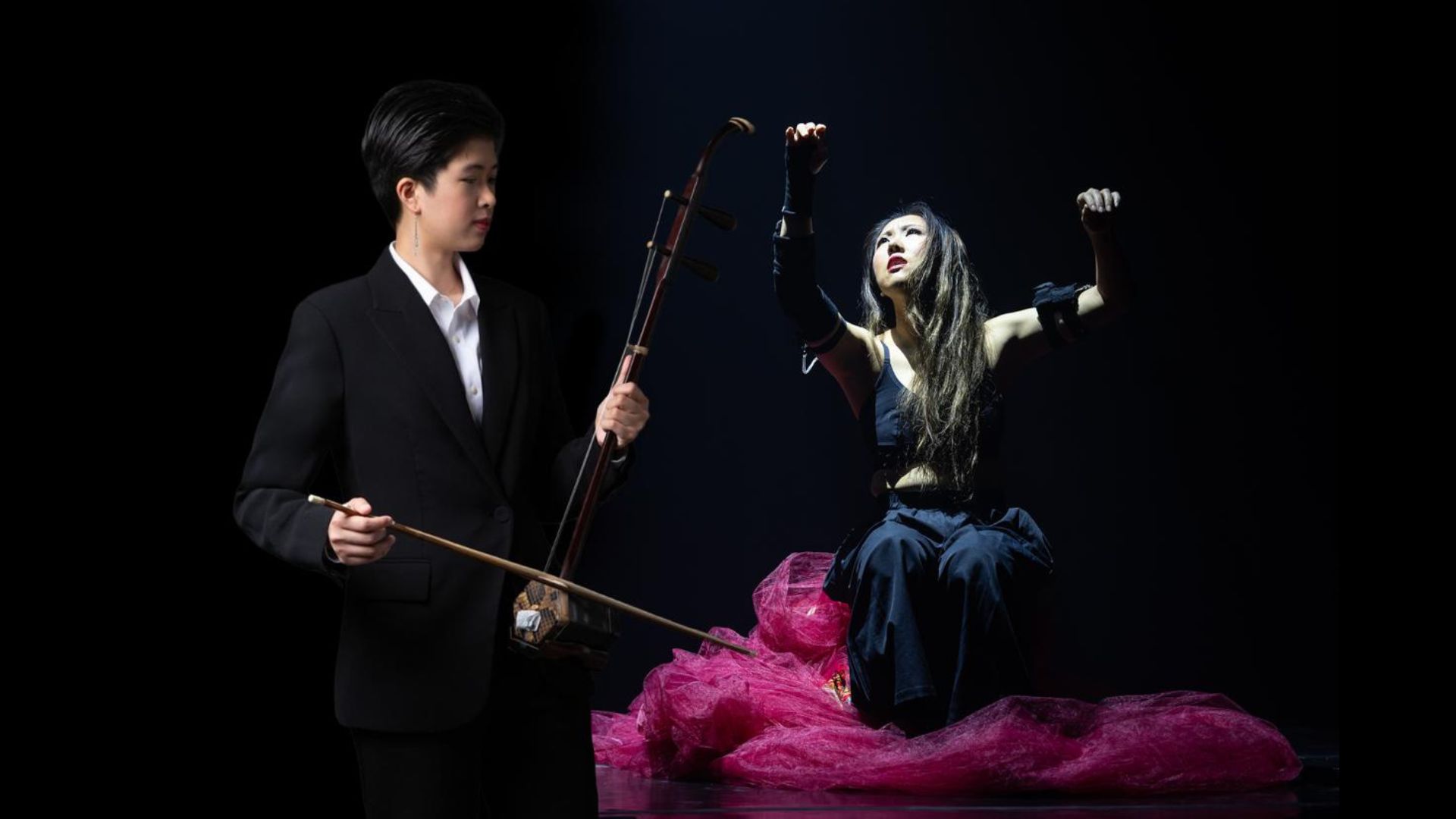 . A man and woman joyfully playing musical instruments together in a vibrant setting.