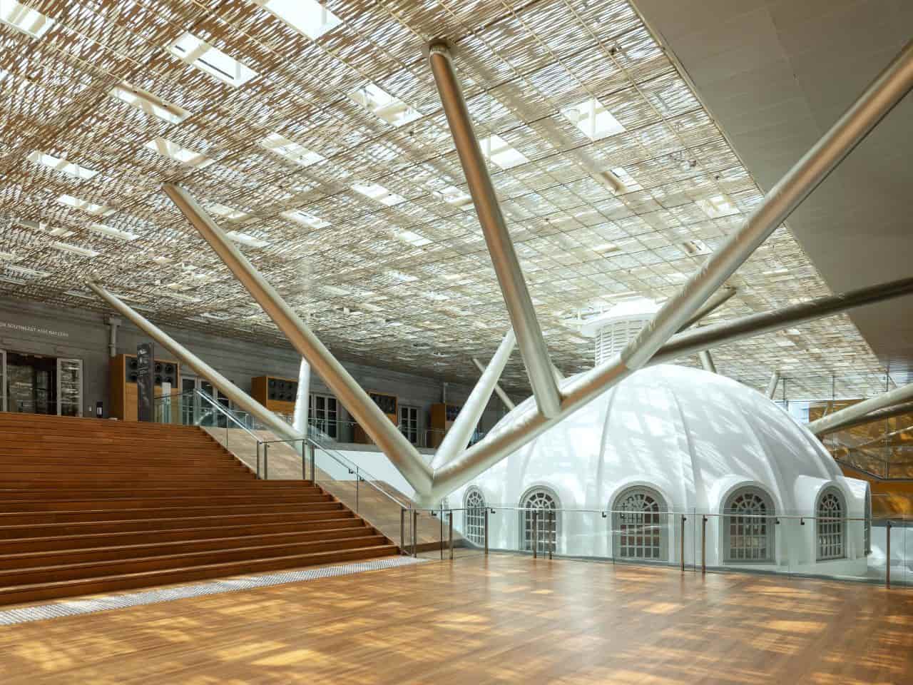 A spacious white dome interior featuring wooden floors and stairs, creating a bright and inviting atmosphere.
