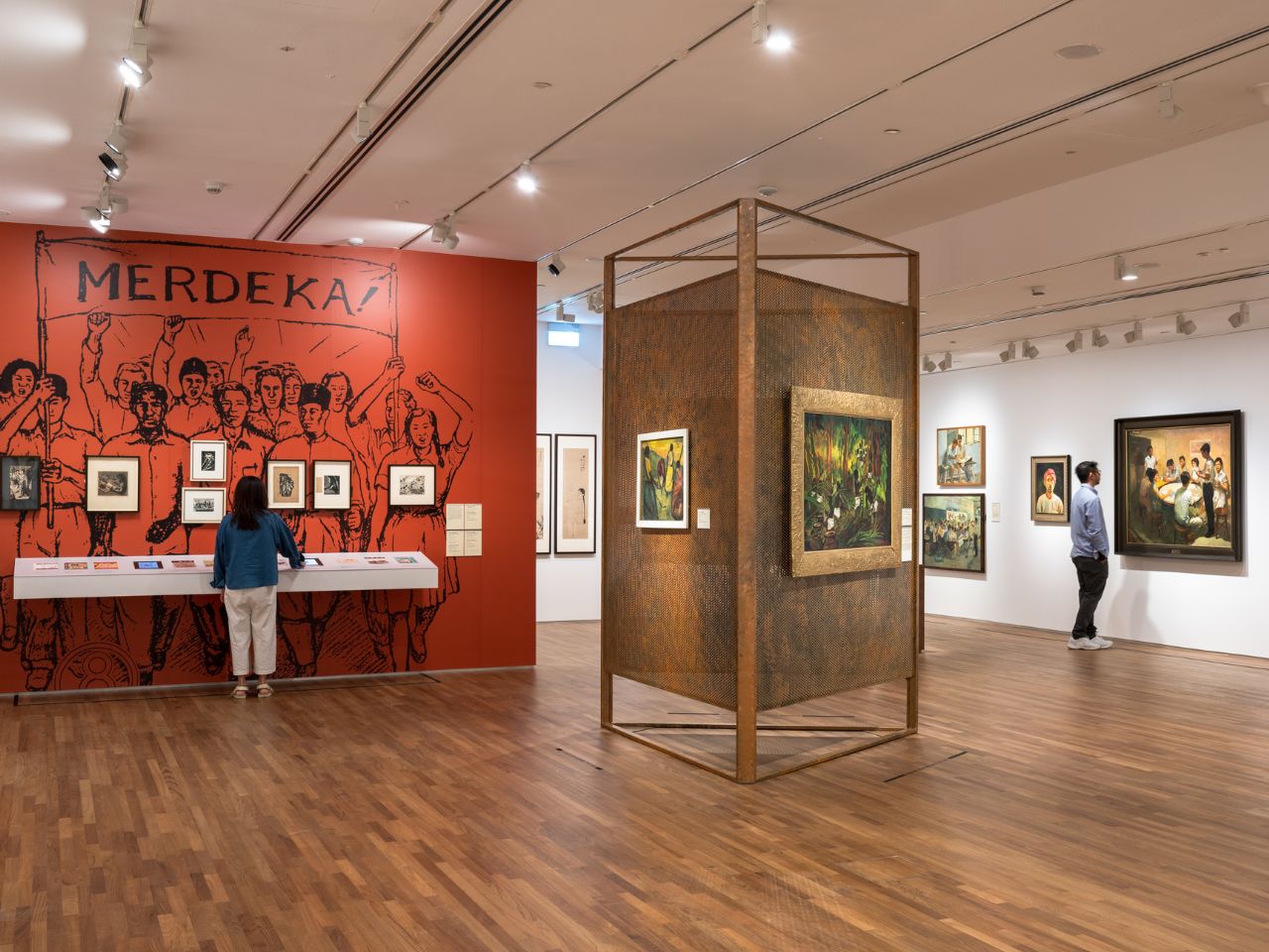 Visitors observe various artworks displayed in a spacious art museum gallery.