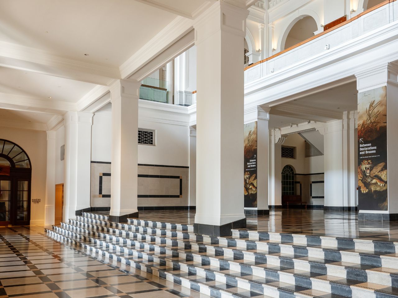 Interior view of a museum featuring a black and white checkered floor and various art displays.