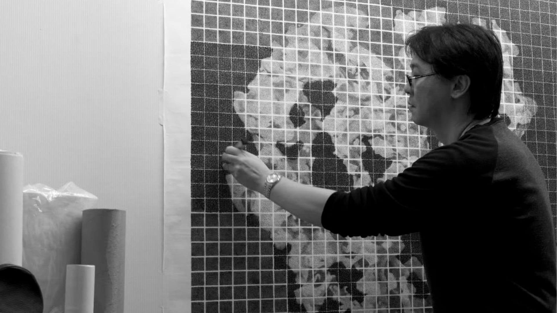 A man is engaged in painting, highlighting his creativity and the artistic atmosphere around him.