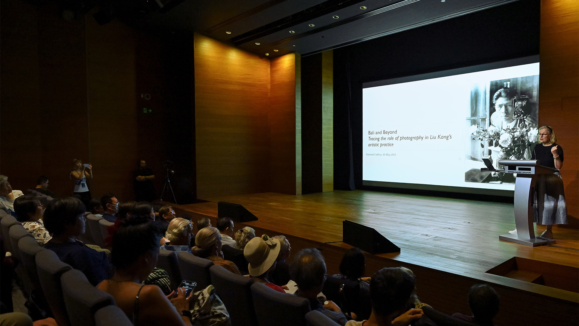 Lecture attendees listen intently to speaker's presentation in an auditorium