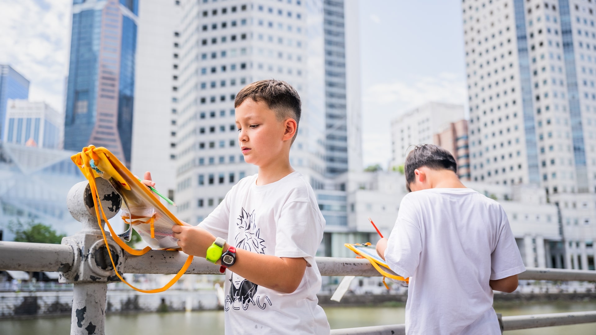 Two children drawing and sketching around the Singapore River